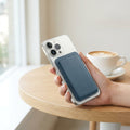 MagSafe leather wallet case on a smartphone at a bright cafe table